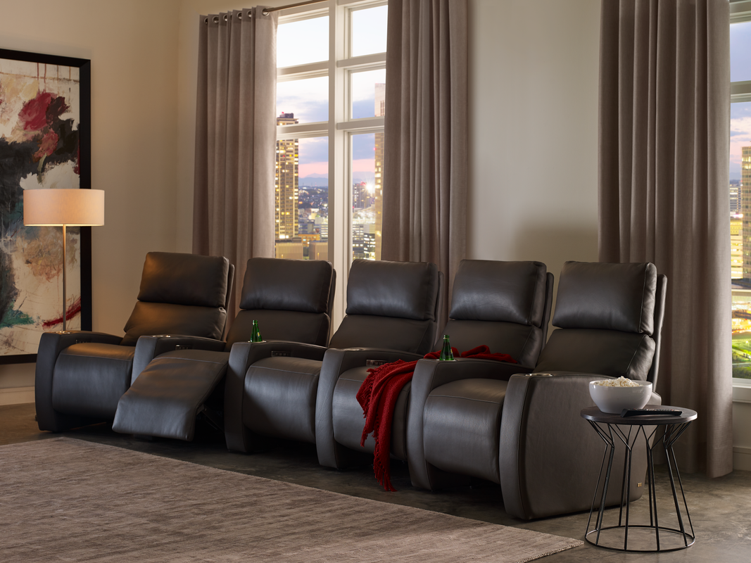 Tiered home theatre room with rows of deep leather reclining seats facing the screen